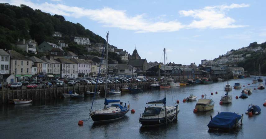 Boats bobbing on the water in a Cornish coastal village