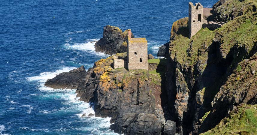 Cornwall's coastline showing waves crashing against the rocks and abandoned mine workings