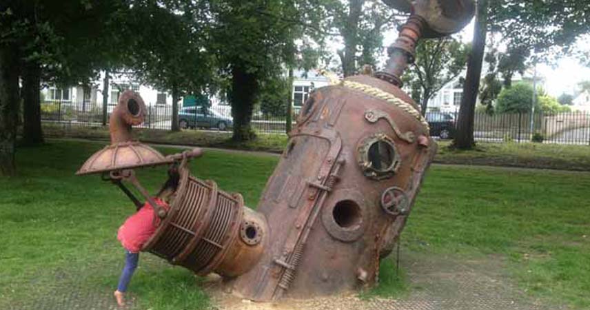 Child playing in a piece of apparatus in a park playground in Falmouth.