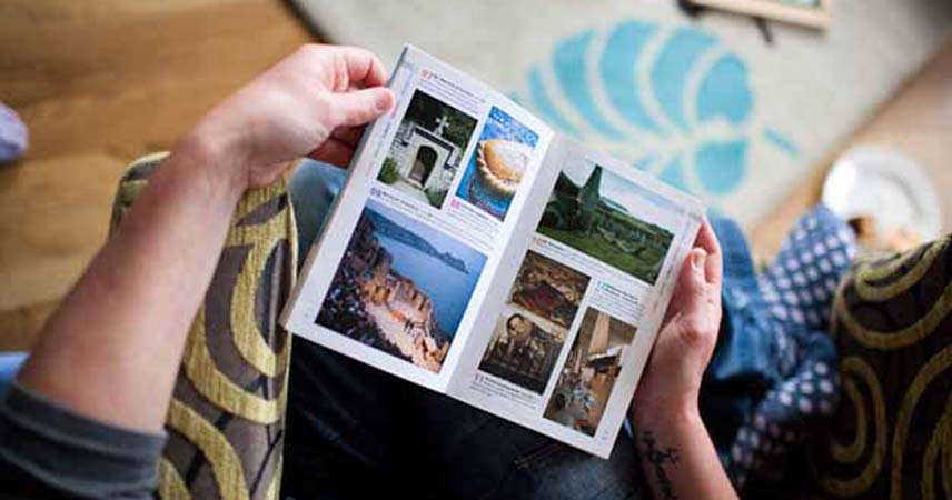 Picture of someone holding a brochure containing places to visit in Cornwall.
