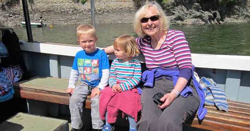 Three people posing on a boat during a day out in Fowey and Polruan in Cornwall.