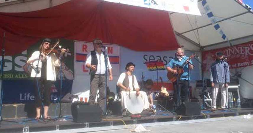 A group of musicians playing sea shanties at Falmouth International Sea Shanty Festival in Cornwall.