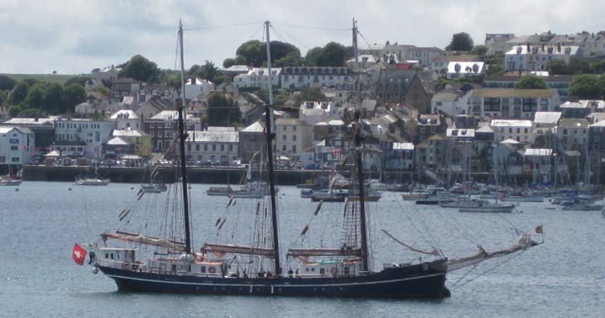 Tall ships in Falmouth, Cornwall, with the town of Falmouth in the background.