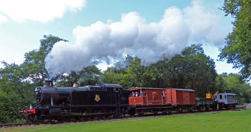 Picture of a steam train with trailers running along a track at Bodmin and Wenford Railway.