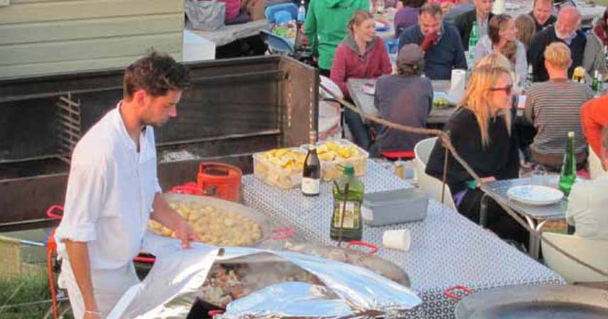 Chef wrapping tin foil around paella cooking dish