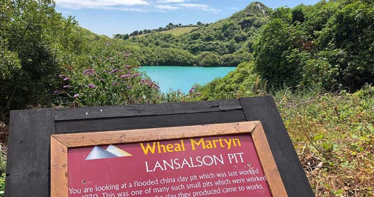 Information point signage for Lansalson Pit with view of the sea and coastline in the background