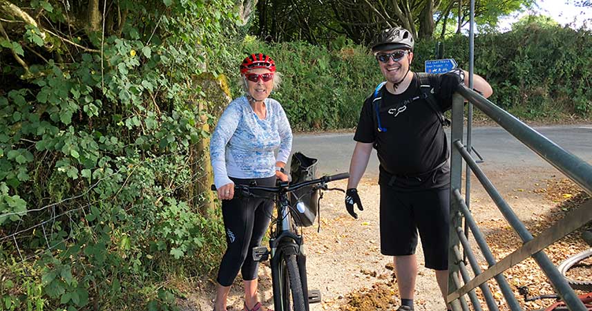 Nanny Pat and male friend in cycling gear with her electric bicycle