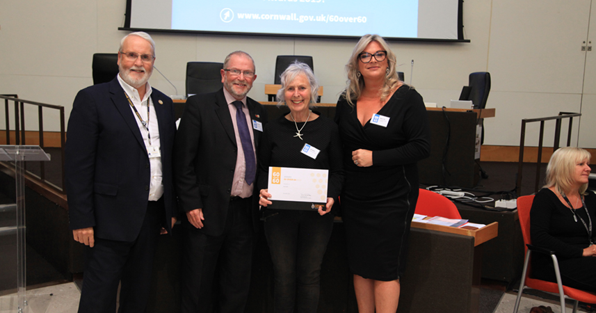 Nanny Pat holding her 60 over 60 certification, stood with 3 members of Cornwall Council