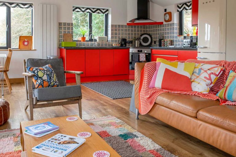 Leather sofa and retro arm chair in the living/kitchen area of Apple Cottage at Bosinver