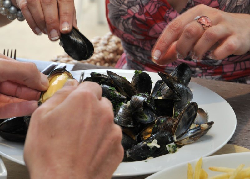 Close up of a couple eating fresh muscles