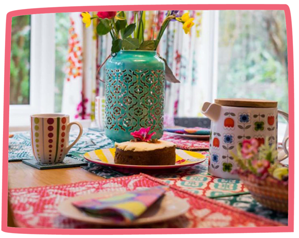 Table set in a cottage at Bosinver with tea and a coffee cake in the middle.