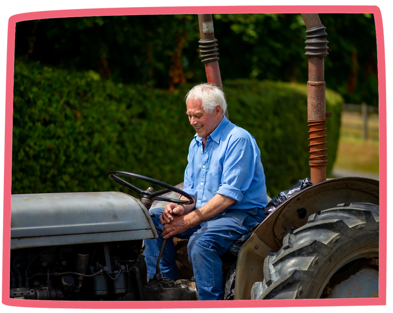 Man driving a tractor on a sunny day at Bosinver.