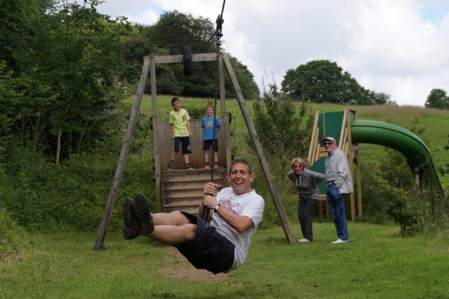 Dad on a zipline being watched by family at Bosinver